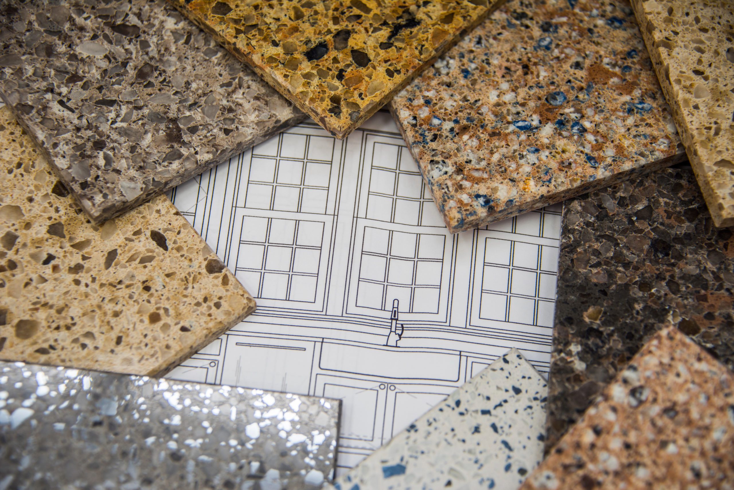 Kitchen countertops and bath counter stone sample colors placed on top of a blueprint layou Kitchen countertops and bath counter stone sample colors placed on top of a blueprint layou