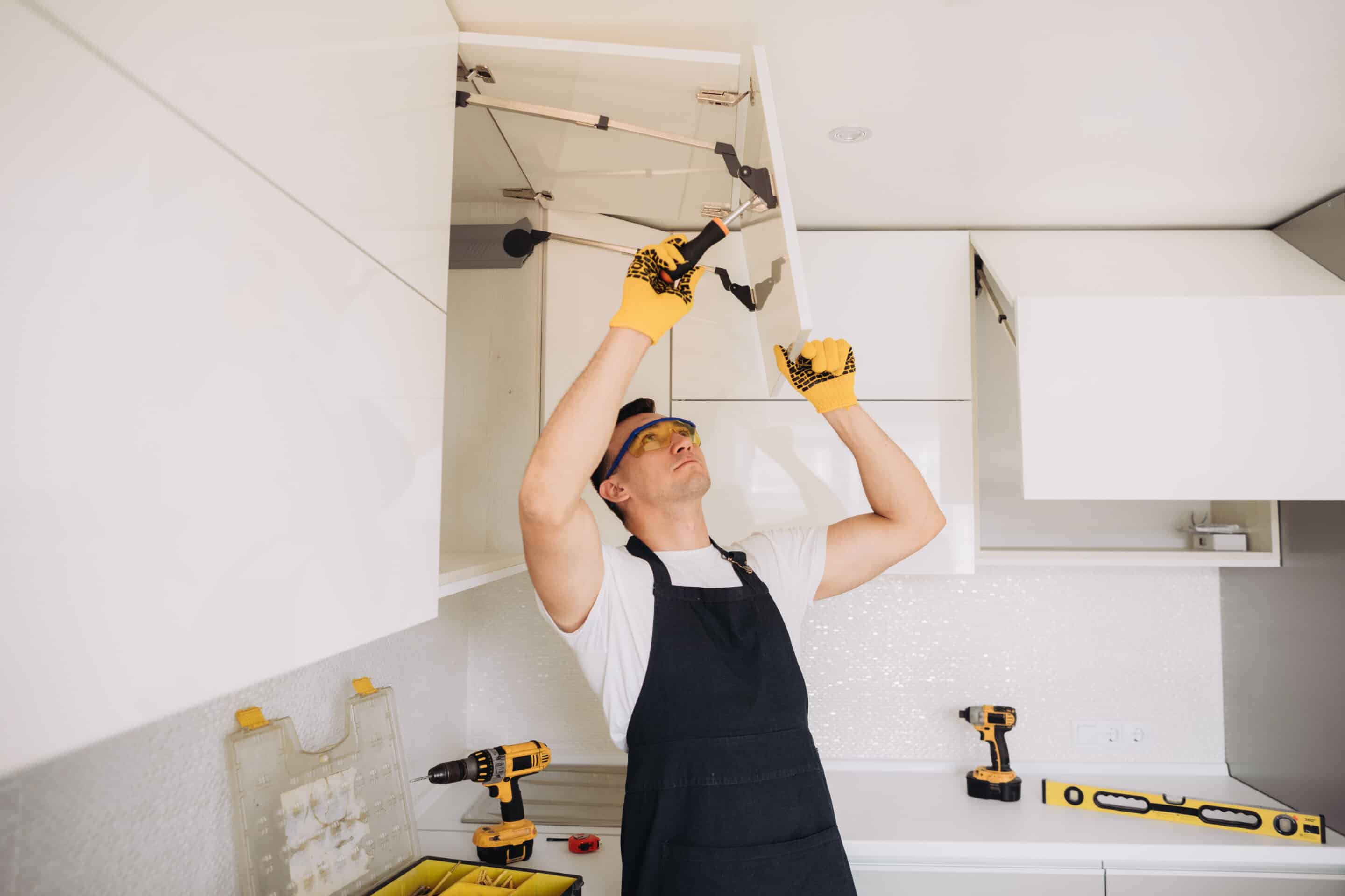 Man installing a kitchen cabinet